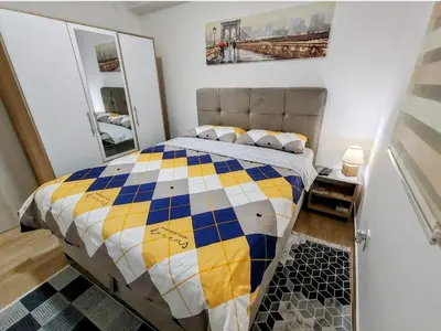 a bedroom with a bed with a checkered blanket at Apartment Violet in Belgrade