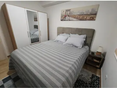 a bedroom with a bed with a striped comforter at Apartment Violet in Belgrade