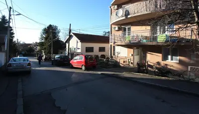 a red car parked on a street next to a building at Apartment Violet in Belgrade