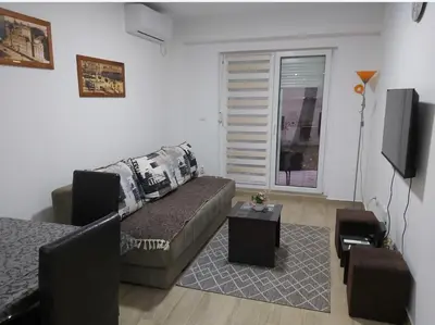a living room with a couch and a tv at Apartment Violet in Belgrade