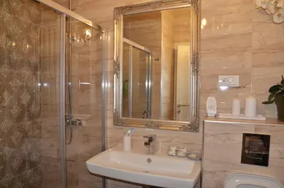 a bathroom with a sink and a shower with a mirror at Apartment ON TOP 23 in Belgrade