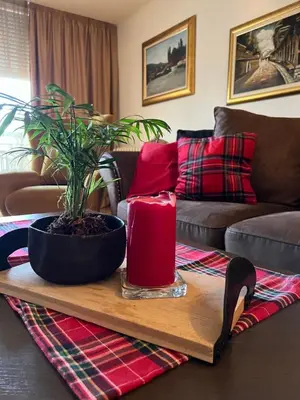 a living room with a table with a plant and a candle at Apartment ON TOP 23 in Belgrade