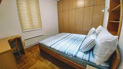a bedroom with a bed with blue and white pillows at Apartment Harmonija in Belgrade
