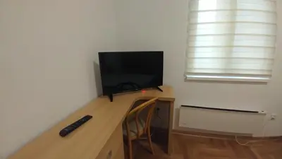 a room with a desk with a television and a chair at Apartment Harmonija in Belgrade