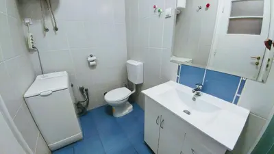a white bathroom with a sink and a toilet at Apartment Harmonija in Belgrade