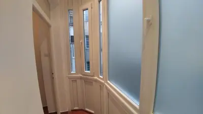a hallway with two windows and a door at Apartment Harmonija in Belgrade
