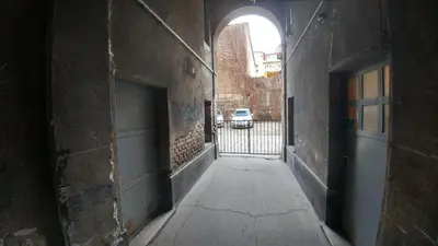 an alley way with a gate and a car in the background at Apartment Harmonija in Belgrade