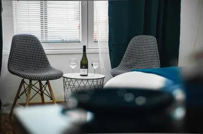 two chairs with a bottle and two glasses of wine at Apartment Atelje Downtown in Belgrade