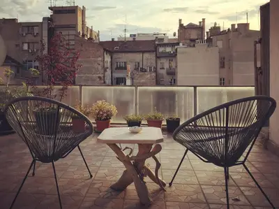 a patio with two chairs and a table on a balcony at Apartment Atelje Downtown in Belgrade
