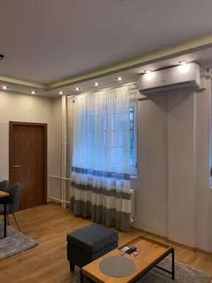 a living room with a table and a window at Rose Lux in Belgrade
