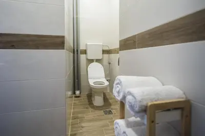 a small bathroom with a toilet and two stools at Rose Lux in Belgrade