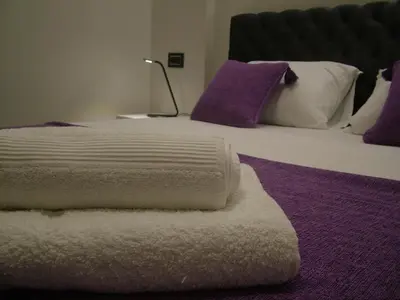 a bedroom with a large bed with purple and white pillows at Rose Lux in Belgrade