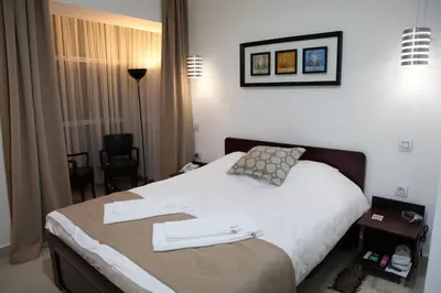 a hotel room with a bed with two towels on it at Hotel Zeder Garni in Belgrade