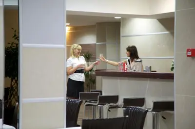 two women standing at a bar in a restaurant at Hotel Zeder Garni in Belgrade