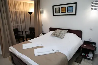 a hotel room with a bed with two towels on it at Hotel Zeder Garni in Belgrade
