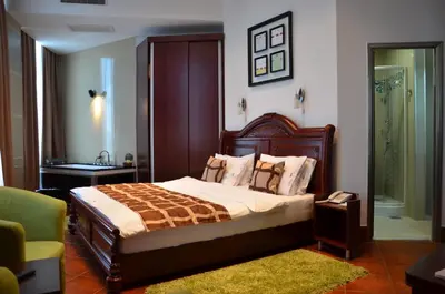 a bedroom with a large bed and a bathroom at Hotel Zeder Garni in Belgrade