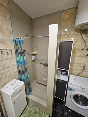 a bathroom with a shower and a television in it at Matea apartman in Belgrade
