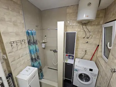 a small bathroom with a washing machine and a washer at Matea apartman in Belgrade
