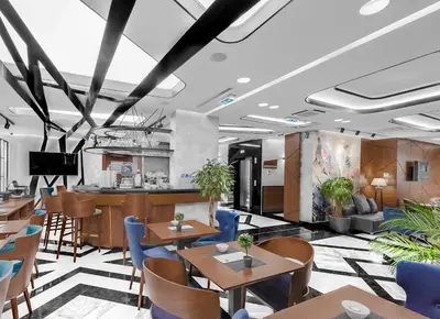 a restaurant with wooden tables and blue chairs at Sky Hotel in Belgrade
