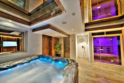 an indoor hot tub in a house with purple lights at Sky Hotel in Belgrade