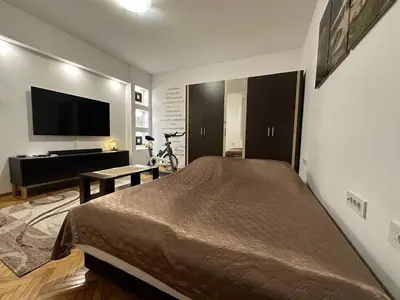 a bedroom with a bed and a flat screen tv at Cherrycity apartments in Belgrade