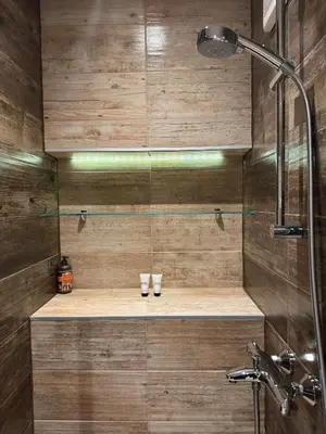 a bathroom with a shower with two glasses on a shelf at Cherrycity apartments in Belgrade