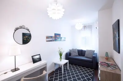a living room with a blue couch and a mirror at A Blok-Apartment The One in Belgrade