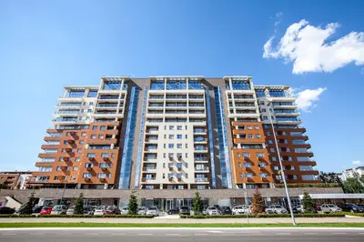 a large tall building with cars parked in front of it at A Blok-Apartment The One in Belgrade