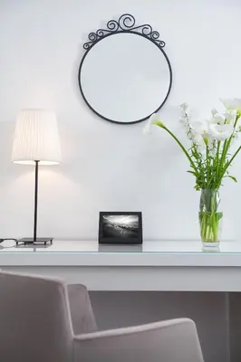 a table with a vase of white flowers and a lamp at A Blok-Apartment The One in Belgrade
