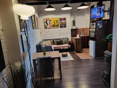 a living room with a table and a couch at Authentic Belgrade Centre - Split Level loft with Patio in Courtyard in Belgrade