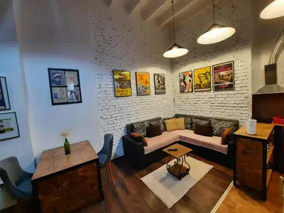 a living room with a couch and a brick wall at Authentic Belgrade Centre - Split Level loft with Patio in Courtyard in Belgrade