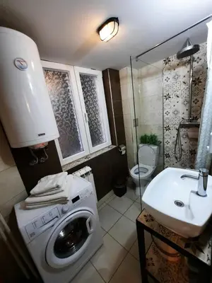 a bathroom with a washing machine and a sink at Authentic Belgrade Centre - Split Level loft with Patio in Courtyard in Belgrade