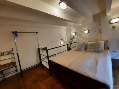 a bedroom with a large bed with two pillows at Authentic Belgrade Centre - Split Level loft with Patio in Courtyard in Belgrade