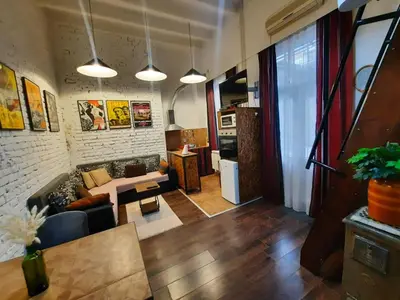 a living room with a couch and a table at Authentic Belgrade Centre - Split Level loft with Patio in Courtyard in Belgrade