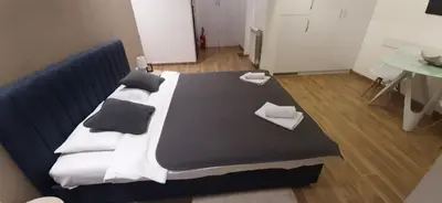a large bed with black and white blankets and pillows at M48 apartments in Belgrade