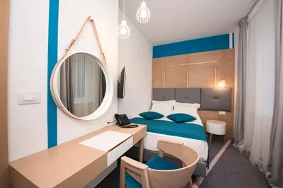 a bedroom with a bed and a desk and a mirror at City Nest Modern & Cozy Suites in Belgrade