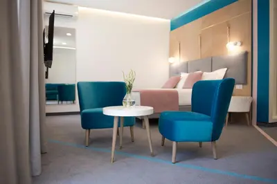 a hotel room with a bed and a table and chairs at City Nest Modern & Cozy Suites in Belgrade