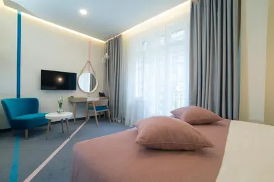 a bedroom with a bed and a desk and a television at City Nest Modern & Cozy Suites in Belgrade