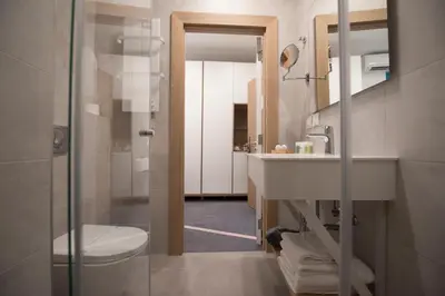 a bathroom with a toilet and a sink and a mirror at City Nest Modern & Cozy Suites in Belgrade