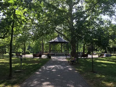 a park with a gazebo and people sitting on benches at Markoni in Pančevo