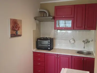 a kitchen with red cabinets and a microwave at Markoni in Pančevo