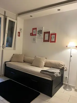 a bed in a room with a lamp and pictures on the wall at Talisman in Belgrade