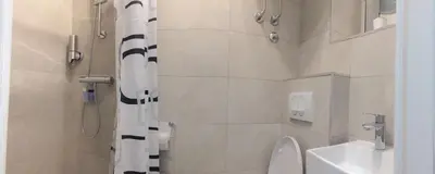 a bathroom with a shower and a toilet and a sink at Talisman in Belgrade