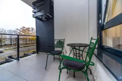 a balcony with two chairs and a table on a building at Apartman Tirena in Belgrade