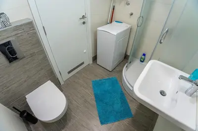 a bathroom with a white toilet and a sink at Apartman Tirena in Belgrade
