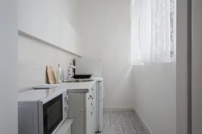 a white kitchen with a sink and a microwave at Apartment Slavija square/Clinical center of Serbia in Belgrade