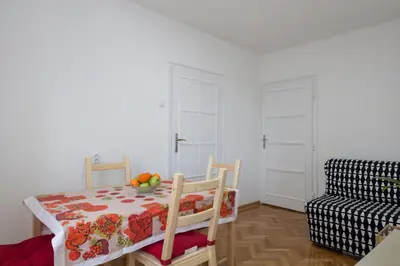 a dining room with a table and chairs and a couch at Apartment Slavija square/Clinical center of Serbia in Belgrade