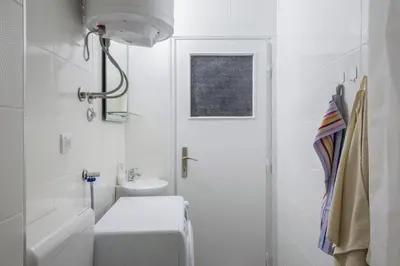 a white bathroom with a toilet and a sink at Apartment Slavija square/Clinical center of Serbia in Belgrade
