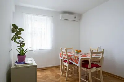 a dining room with a table and chairs and a window at Apartment Slavija square/Clinical center of Serbia in Belgrade