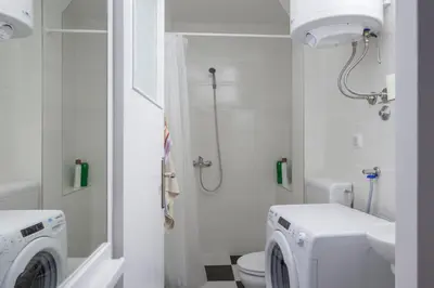 a bathroom with a washing machine and a toilet at Apartment Slavija square/Clinical center of Serbia in Belgrade